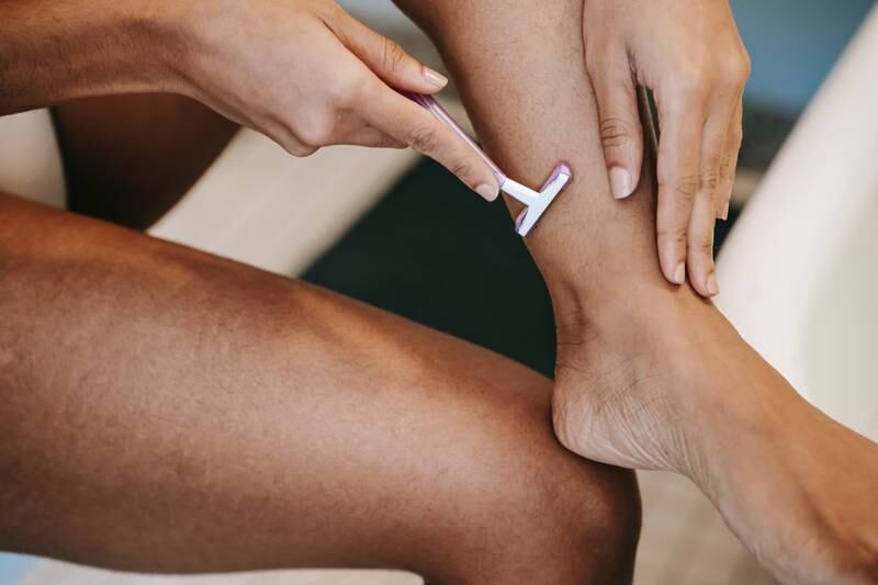 Mulher depilando a perna