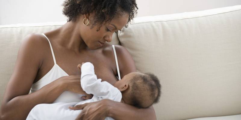 Mulher negra amamentando bebê
